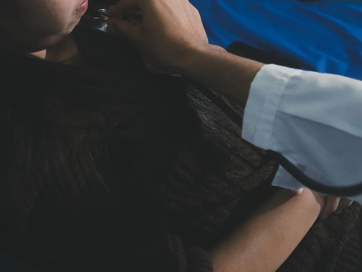 Clinician listening to a patient's chest with a stethoscope